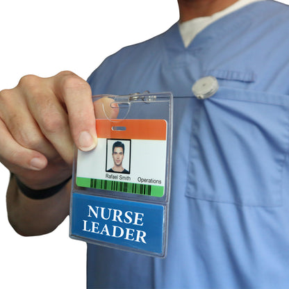 A person in blue scrubs holds up a NURSE LEADER Badge Buddy, displaying an ID badge with the name Rafael Smith, Operations. Sold by Specialist ID.