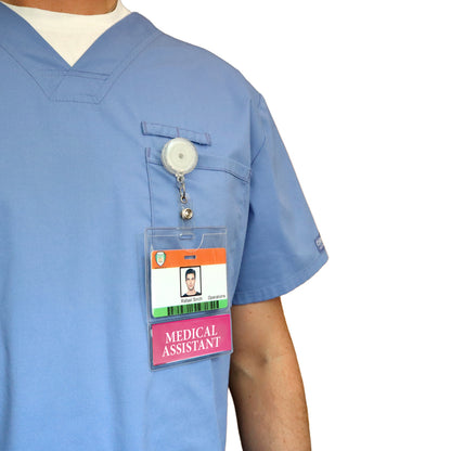 A person in a blue medical uniform wears a "MEDICAL ASSISTANT BadgeBottom Badge Holder & MEDICAL ASSISTANT Badge Buddy IN ONE" attached to the chest pocket. Sold by Specialist ID.