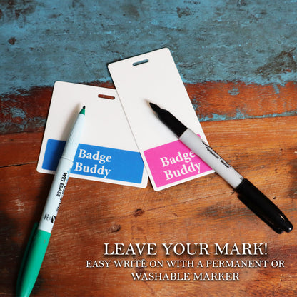 Two blank "Oversized NURSE Badge Buddy - Extra Large Badge Buddies for Nurses - Vertical Hospital ID Badge Backer" cards on a wooden surface placed next to a green washable marker and a black permanent marker, perfect for any healthcare setting. Text reads: "LEAVE YOUR MARK! Easy write on with a permanent or washable marker.
