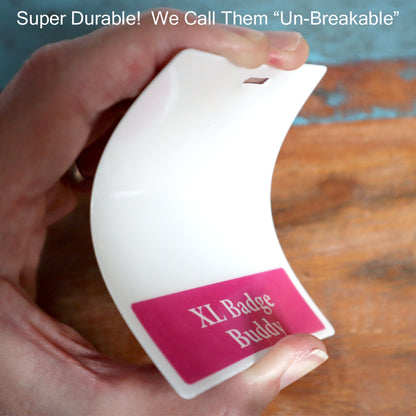 A hand bending a white badge with a pink label reading "Oversized LPN Badge Buddy - XL Badge Backer for Nurses - Horizontal Hospital ID Badge Buddies." The text above reads, "Super Durable! We Call Them 'Un-Breakable.'" Perfect for healthcare settings like Licensed Practical Nurses.
