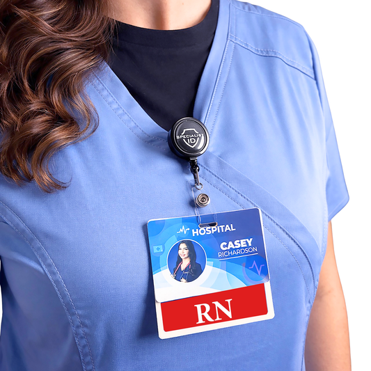 A person in light blue medical scrubs and a black undershirt has a durable healthcare badge and an RN Registered Nurse Badge Buddy - Horizontal Hospital ID Role Identifier clipped to their chest.