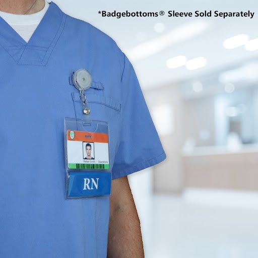 A person in a blue medical uniform with an RN badge holder containing an ID card and a pen, standing in a blurred hospital setting, showcases Horizontal Custom BadgeBottoms Insert Only (Holder Not Included) - Add Your Unique Title perfect for the dynamic medical workplace.