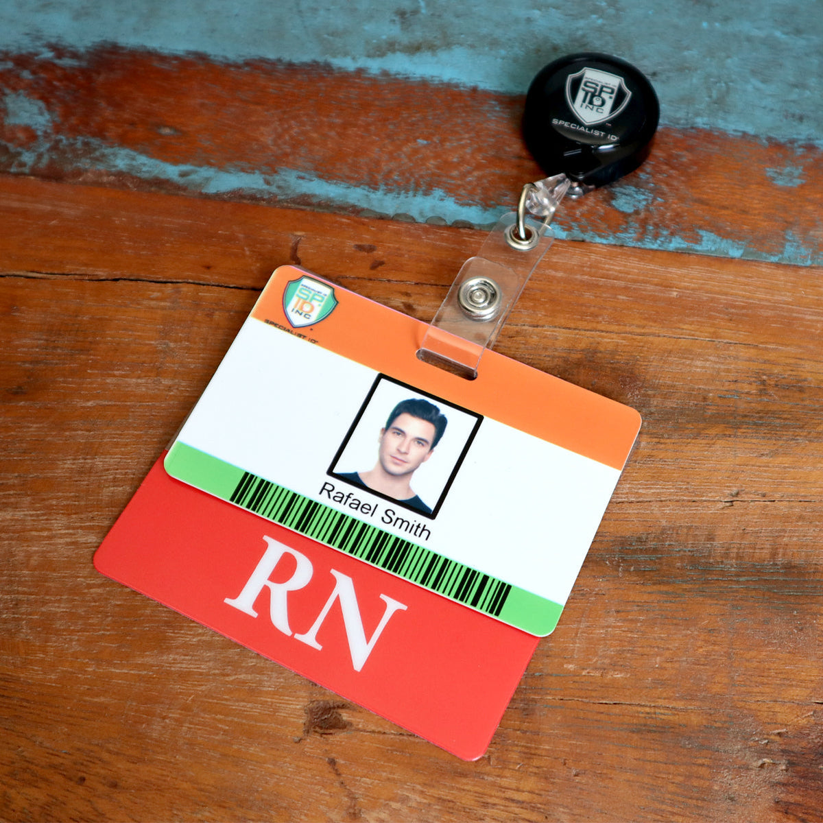 Clear horizontal badge buddy behind a hospital photo ID, with the red RN title bar showing below the ID