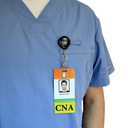 A person wearing blue scrubs with a name badge and a Clear CNA Badge Buddy Vertical with Yellow Border for Nursing Assistants attached to a clip on the chest pocket. Sold by Specialist ID.