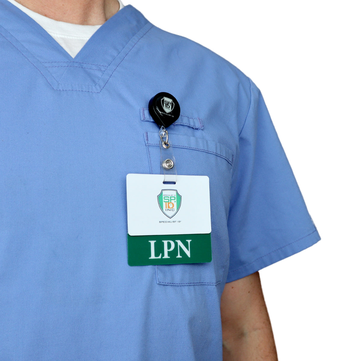 In a busy healthcare setting, a person wearing blue scrubs with a clear LPN Badge Buddy - Horizontal ID Badge Backer for Licensed Practical Nurses - Double Sided Print clipped to the chest pocket efficiently navigates their tasks.