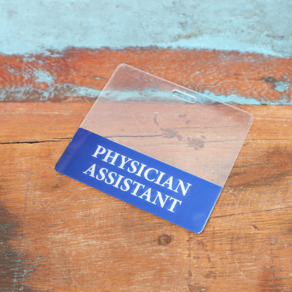 The Clear PHYSICIAN ASSISTANT Badge Buddy is a horizontal, double-sided nurse ID badge backer featuring "PHYSICIAN ASSISTANT" in white on blue, ideal for clear role recognition. Sold by Specialist ID.