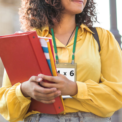 A person wearing a yellow blouse and holding a red binder with papers is seen from the chest down. They have an ID badge holder on a **Double Clip Lanyard with 2 Bulldog Clips - Flat, Soft Material Neck Straps for Large Badge Holder Credentials (2140-530X)** around their neck.