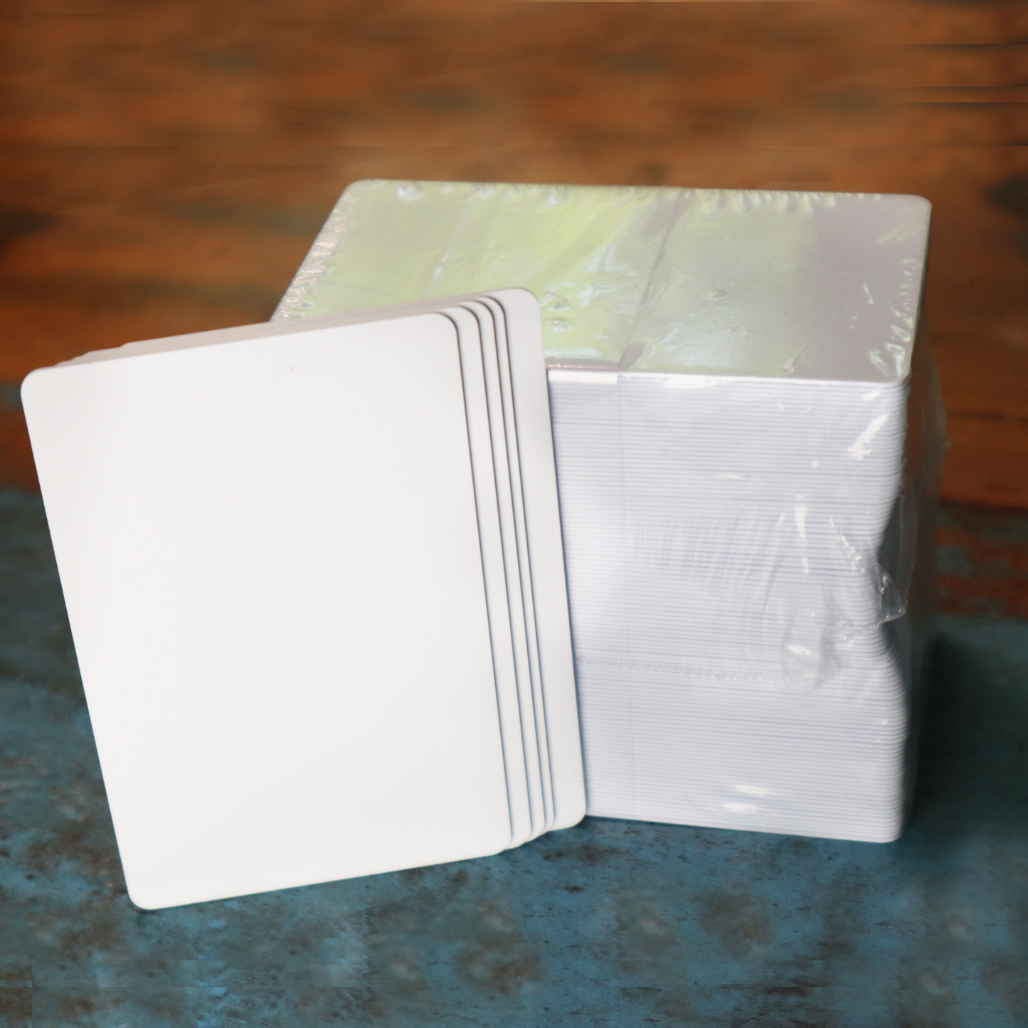 Blank white composite PVC/PET cards on wood surface