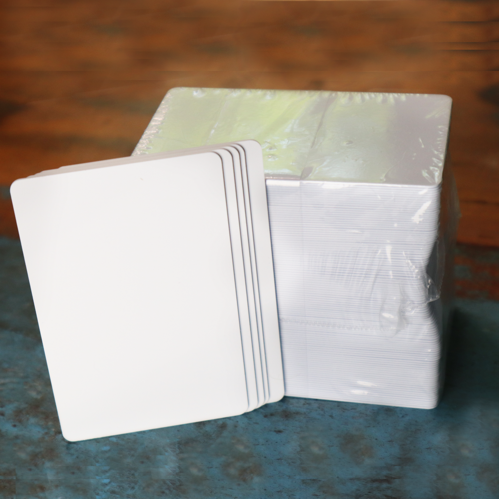 Blank white composite PVC/PET cards on wood surface