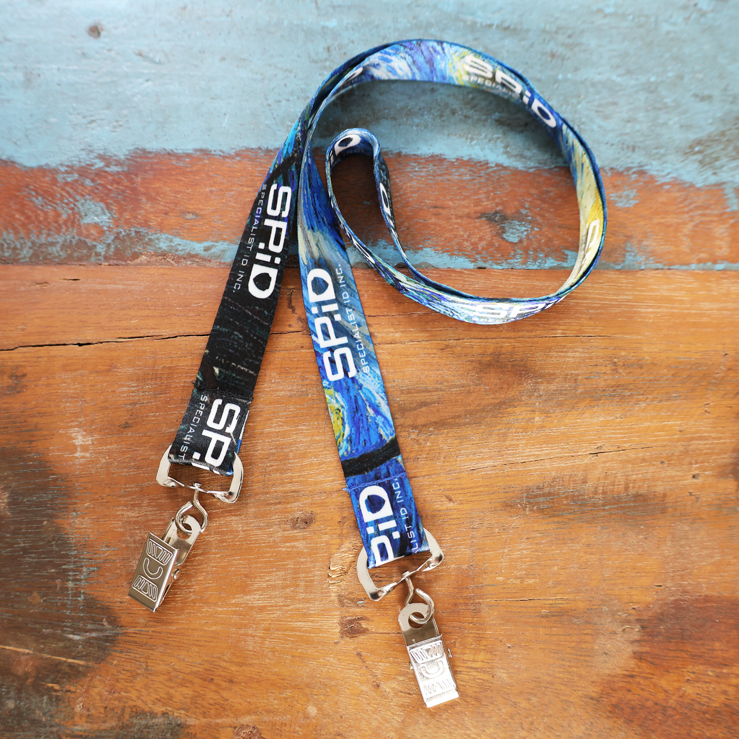 Custom Double Ended Lanyards with 2 clips for event ID badges and name tags are shown on a blue-painted wooden surface, personalized with your logo, text, or artwork for professional customization and quality printing.