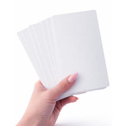 A hand holding a fanned-out stack of blank white cards against a white background, perfect for showcasing the results after using the Magicard E9887 Cleaning Kit for the Magicard Prima 8 ID Card Printer.