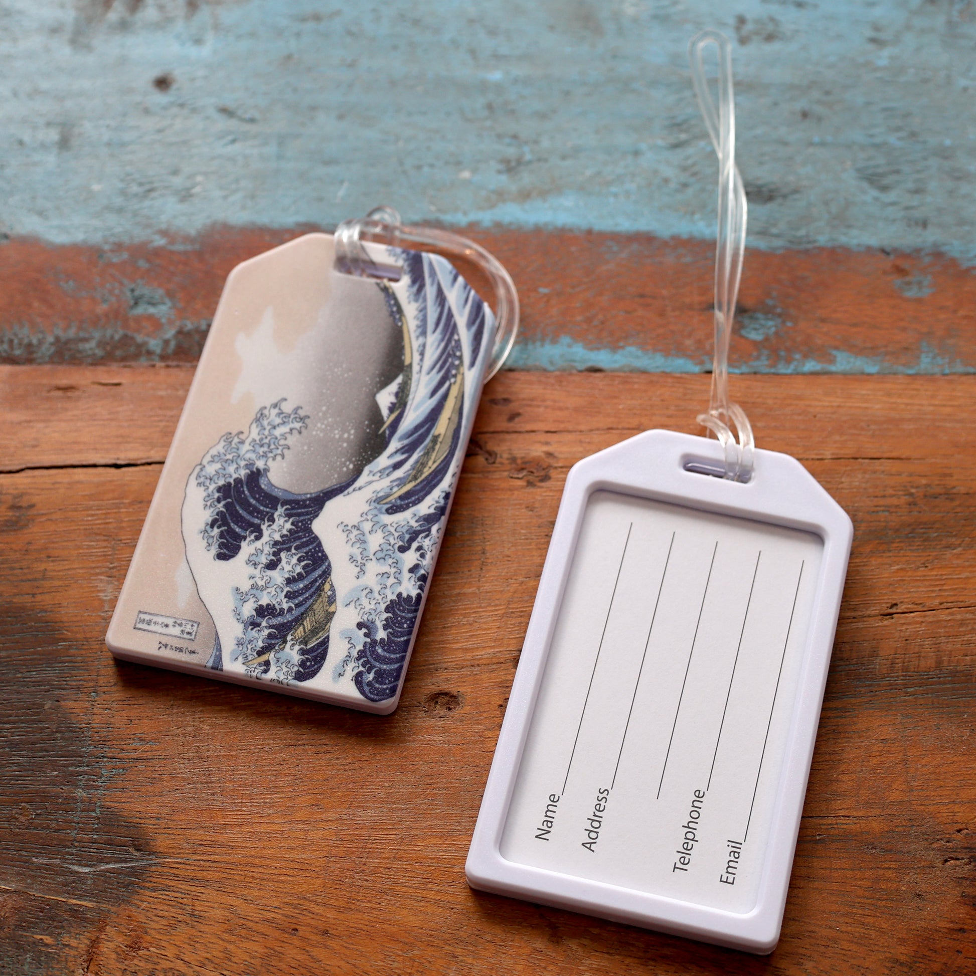 Heavy Duty Luggage Tag with Great Wave design on front side and white frame with clear window insert on the other side for contact information or business card (standard credit card size). Included 6 inch worm loop to attach to suitcase, bags, and more.