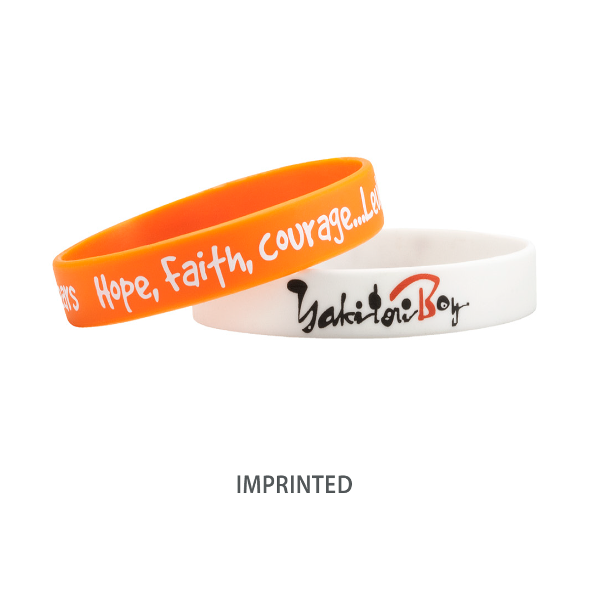 Two high-quality Customizable Adult 1/2" Silicone Wristbands: one orange with the text "Hope, Faith, Courage..." in white, and one white with the text "Yakitori Boy" in black and red. The word "IMPRINTED" appears below. Perfect for promoting a cause or customizing for your needs.
