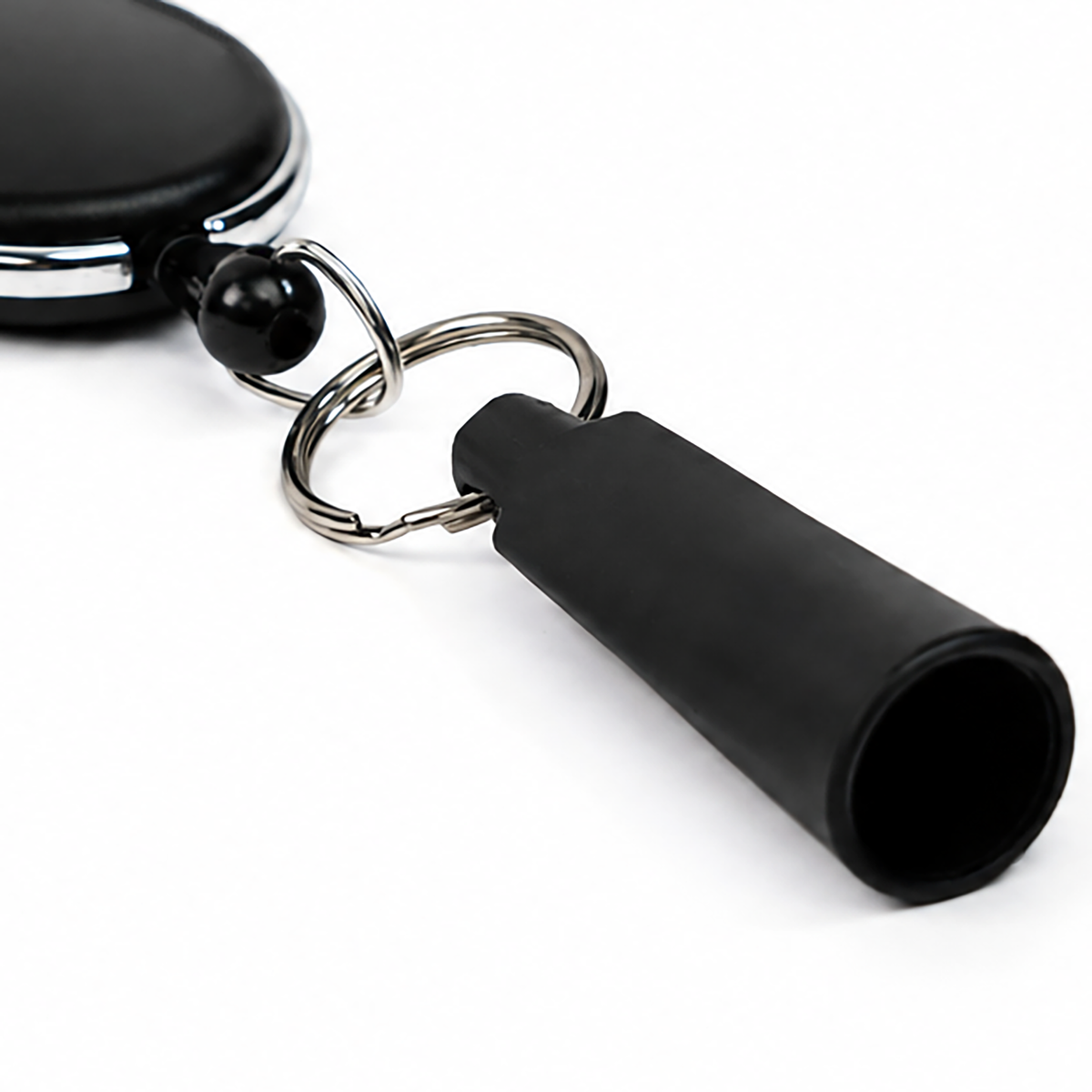 A black whistle keychain attached to a metal key ring, shown on a white background, makes an excellent companion for the Retractable Pen & Pencil Holder Badge Reel with Carabiner Clip (SPID-3280).