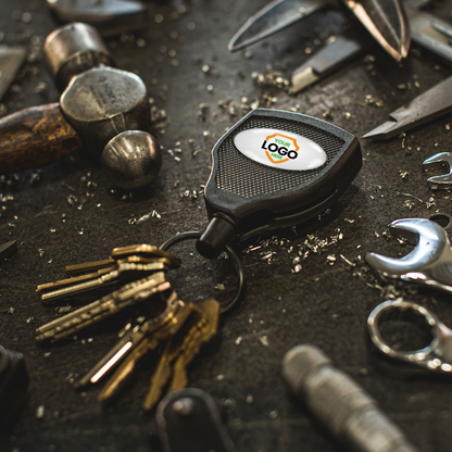 A set of keys with a Customizable Key-Bak Super 48 Heavy Duty Key Reel (S48K) - Customize with Your Own Logo and Design rests on a workbench surrounded by various metal tools, shavings, and the rugged durability one expects from high-quality gear.