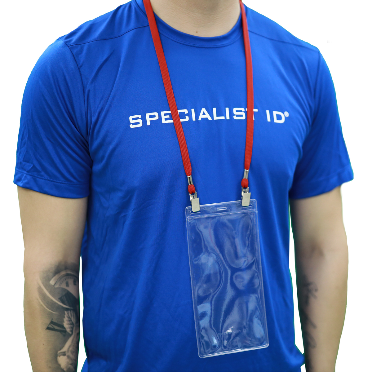 A person wearing a bright blue t-shirt with 'SPECIALIST ID' printed on the chest, wearing a red double clip lanyard with a clear 4x8 plastic pouch holder.