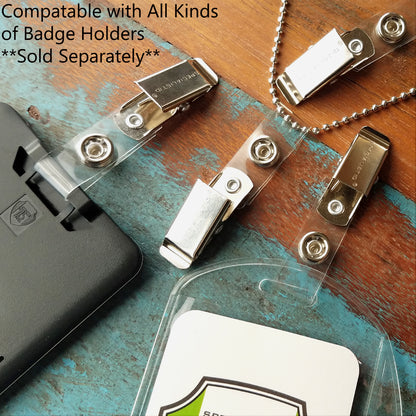 Various Clothing Friendly ID Badge Clips with Smooth Bulldog Clip and Vinyl Strap, including those with vinyl straps and bulldog clips, are displayed on a wooden surface alongside a plastic badge holder and a black attachment. Text reads: "Compatible with All Kinds of Badge Holders Sold Separately".