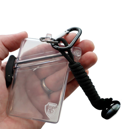 A hand holds the Clear Waterproof ID Badge Holder with Lanyard and Carabiner (P/N SPID-1690), featuring crush-resistant plastic, a black lanyard, and an attached carabiner clip.