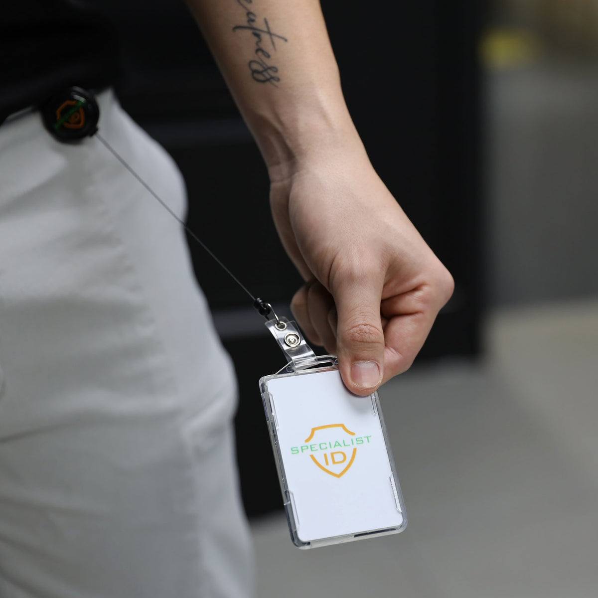 A person holding a Dual RFID Blocking Badge Holder for Smart Cards, CAC, PIV & TWIC (SPID-1720) with an ID card securely attached to their waist.