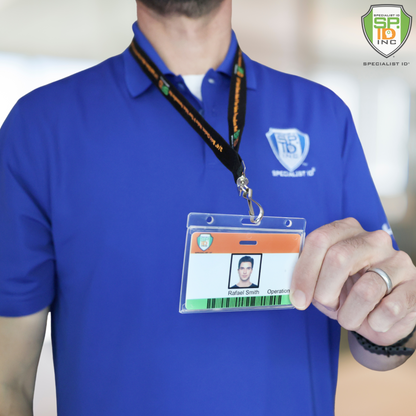 A person in a blue polo shirt holds up the Horizontal Economy Crystal Clear Card Dispenser (P/N 726-CT1), which displays an employee ID with photo, name, and title, and features a thumb notch for easy removal from its holder.