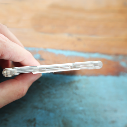A hand holds a slim smartphone in a clear case, beside the Specialist ID Dual Sided RFID Blocking Badge Holder Horizontal (SPID-1760)—a heavy-duty 13.56 MHz shielded protector for CAC, TWIC, PIV, HSPD-12, and secure ID badges.