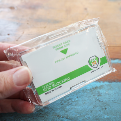 A hand holds the Specialist ID Dual Sided RFID Blocking Badge Holder (SPID-1760), labeled "Insert Card From Side," "FIPS-201 Approved," and "Made in Taiwan," featuring 13.56 MHz protection for secure CAC, TWIC, PIV, and HSPD-12 badges.