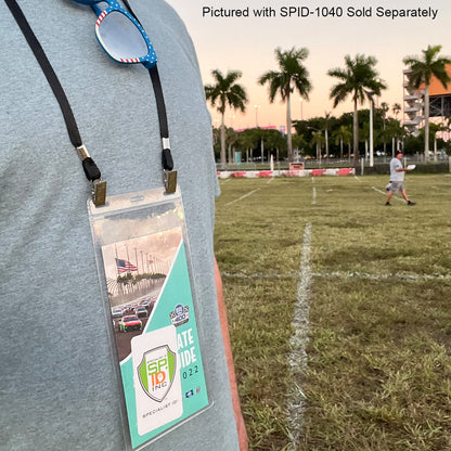 A person sporting a double-sided lanyard with ID badges stands on a grassy field, framed by palm trees and a race track in the background. Text at the top reads "Pictured with Double-Ended Lanyards with Bulldog Clips on Each Side - Comfort Neck Straps ID Holder for Special Event Badges Sold Separately.