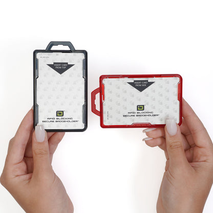 Two hands hold Identity Stronghold RFID Blocking Secure ID Badgeholder DuoLite 2 Sided Shielded Badge Holders in black and red against a white background. Each durable polycarbonate holder contains a card instructing users to insert cards from the top or side, and blocks 13.56MHz signals for enhanced security.