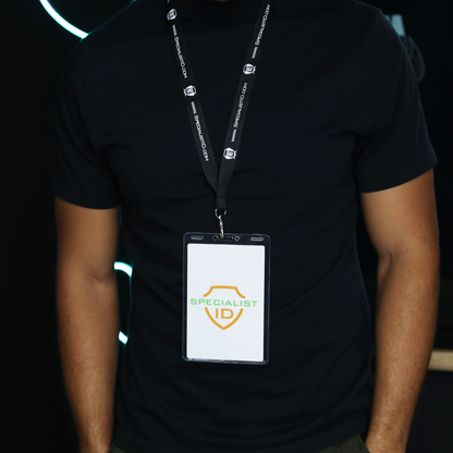 Person wearing a black shirt and a lanyard with a badge featuring a yellow shield and the words “Specialist ID” in green text, displayed inside a Vertical 4x6 Oversized Vinyl Badge Holder (XL46V).