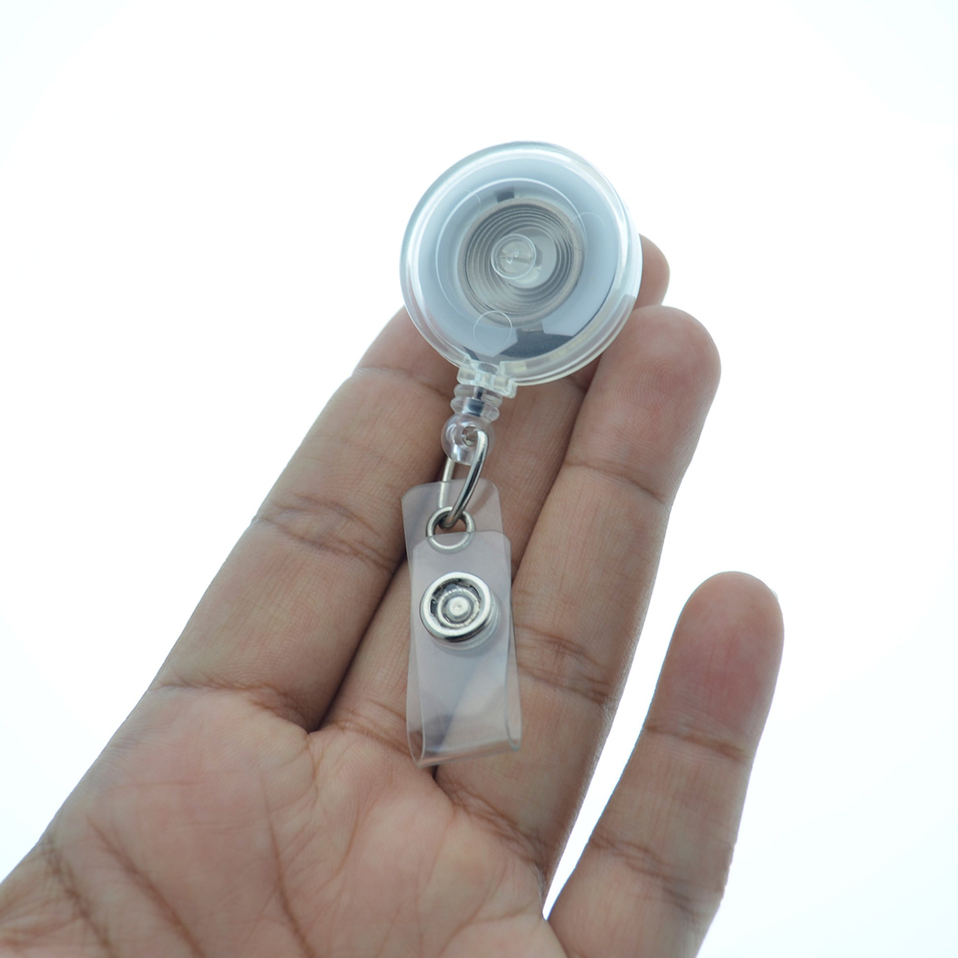 Hand holding clear translucent retractable badge reel with clear vinyl strap.