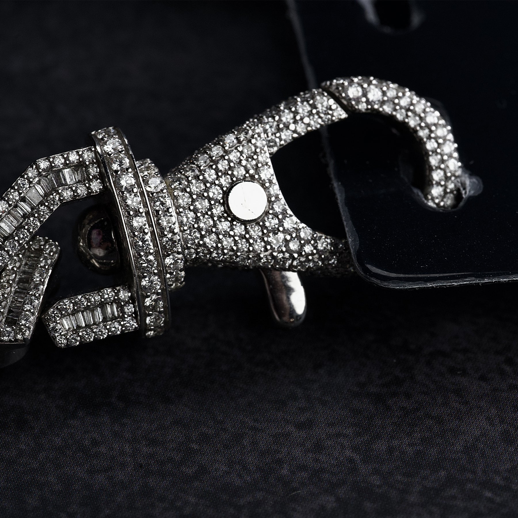 Macro detail of diamond-studded snap clasp on VIP credential chain