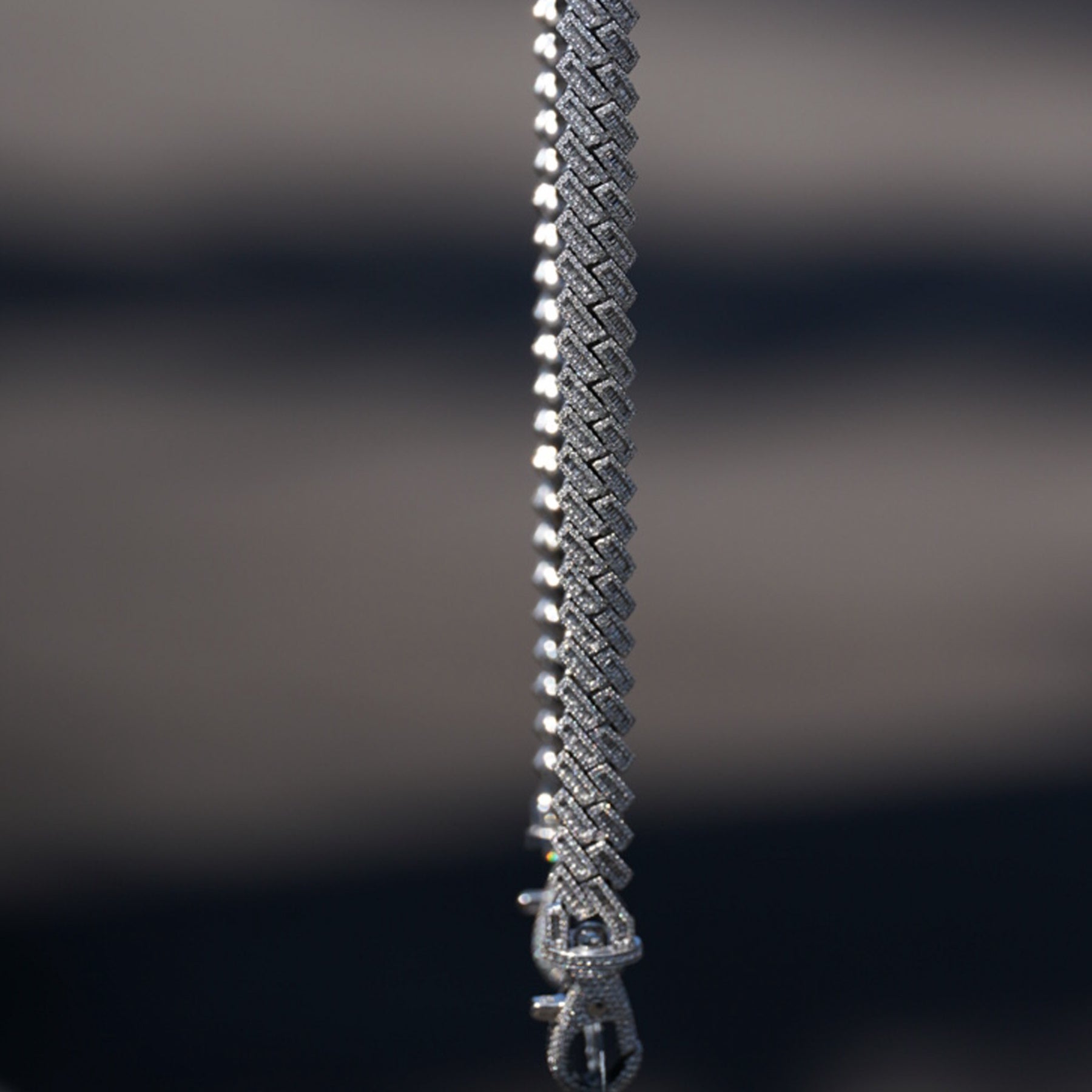 Vertical side view of diamond studded VIP credential chain links and clasp