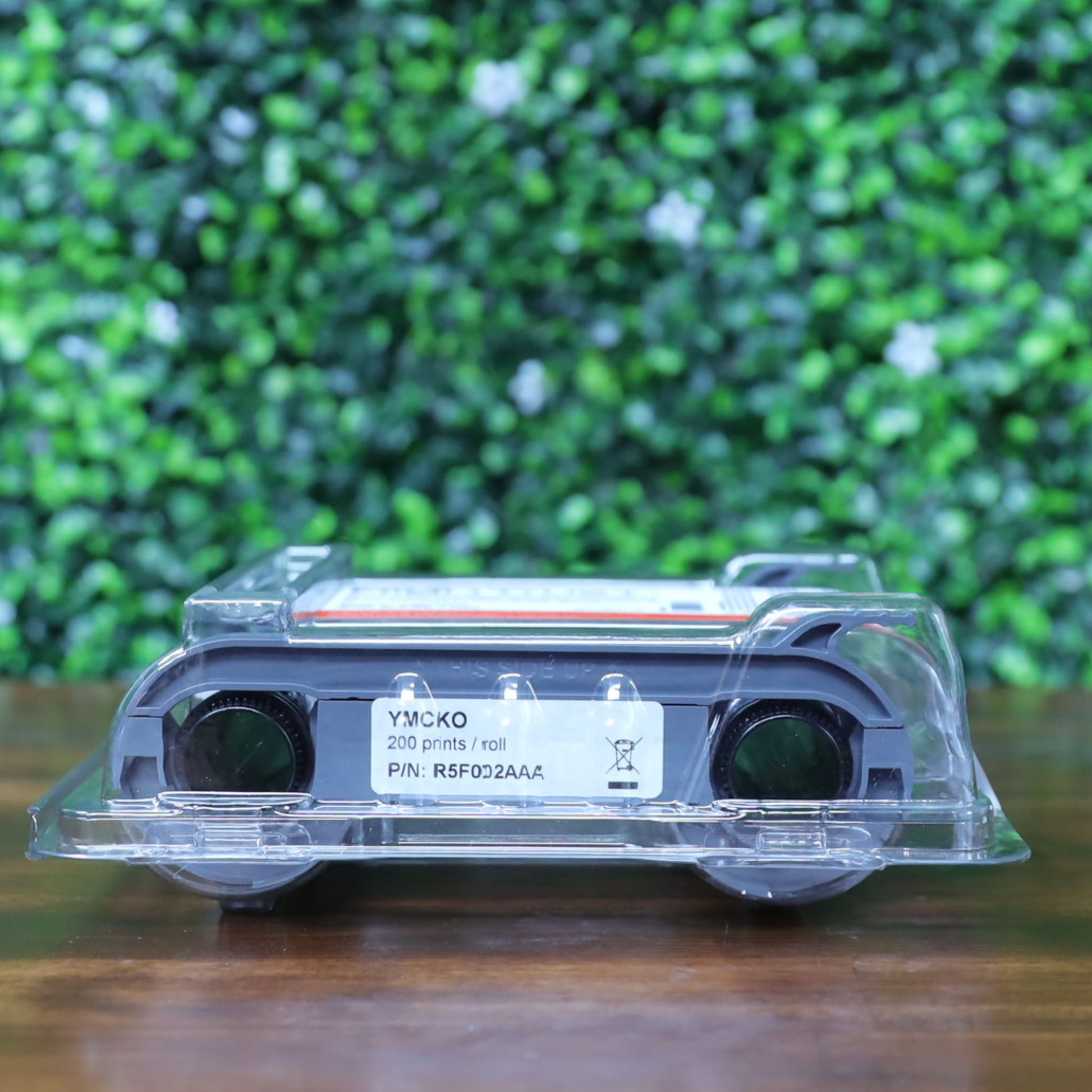 Bottom view of Evolis R5F002AAA YMCKO ribbon in clear plastic clamshell packaging, laying on its back. Label shows part number and 200-print yield. Photographed and sold by Specialist ID, an authorized Evolis dealer.
