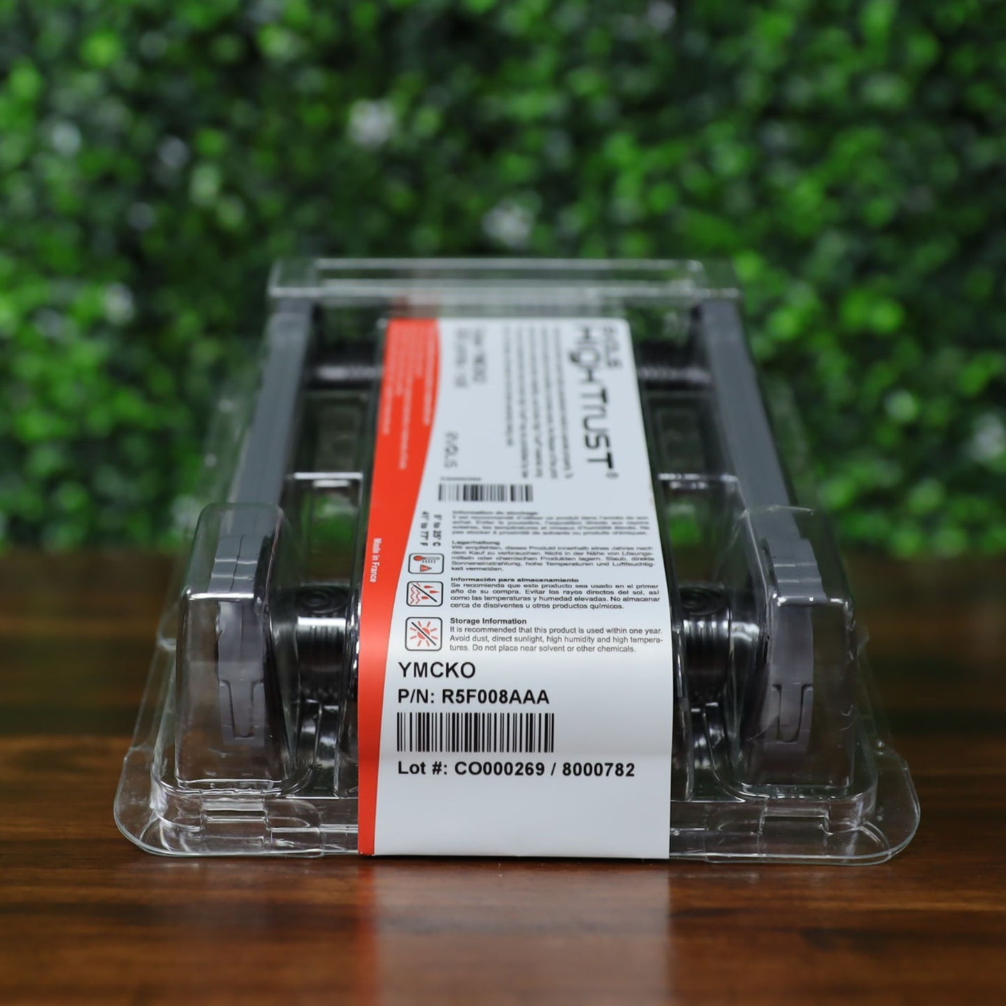 Angled view of packaged Evolis R5F008AAA YMCKO ribbon showing part number, lot number, and storage instructions on white label. Photographed and sold by Specialist ID, an authorized Evolis dealer.