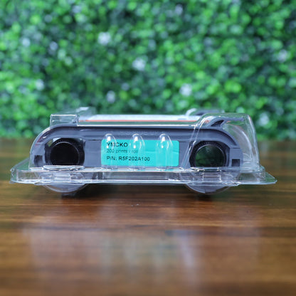 Bottom view of sealed Evolis R5F202A100 YMCKO ribbon cartridge with green label showing 200 prints per roll for Primacy 2 ID Card Printer, inside clear High Trust packaging on wood table with green foliage background. Photographed and sold by Specialist ID, an authorized Evolis dealer.
