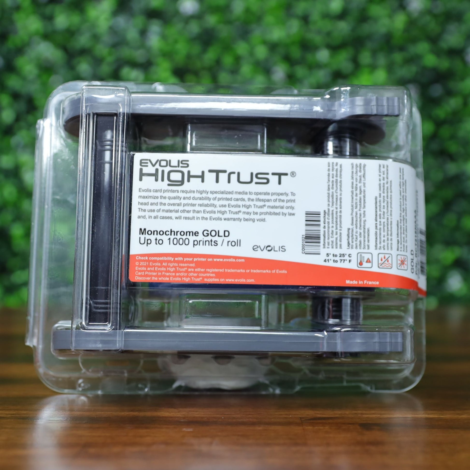 Front-facing photo of Evolis RCT216NAAA metallic gold monochrome ribbon in retail packaging with visible High Trust branding and 'up to 1000 prints / roll' capacity label. Photographed and sold by Specialist ID, an authorized Evolis dealer.