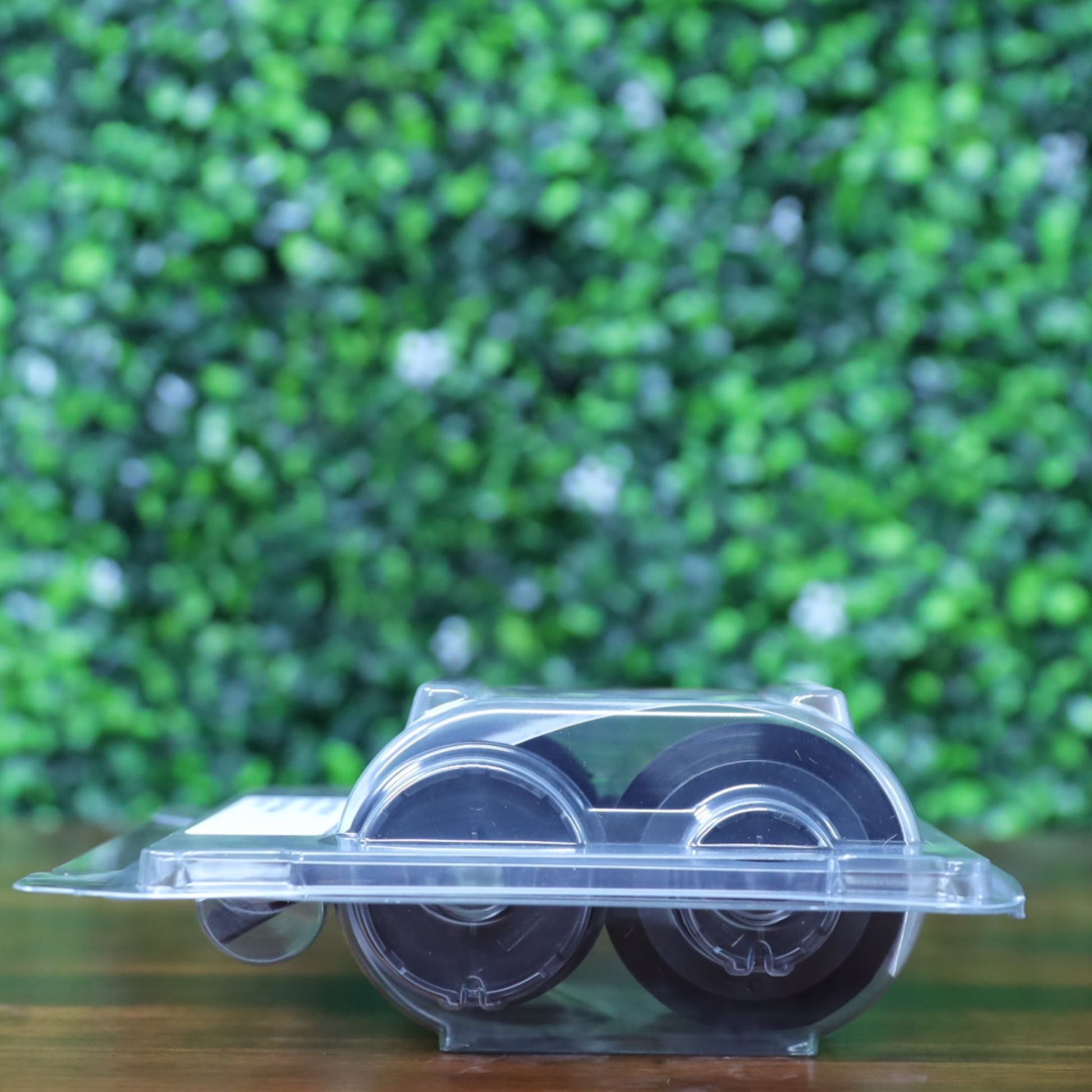 Side view of the Evolis RT4F010AAA YMCK ribbon showing sealed clamshell packaging with both black spools visible. Photographed and sold by Specialist ID, an authorized Evolis dealer.