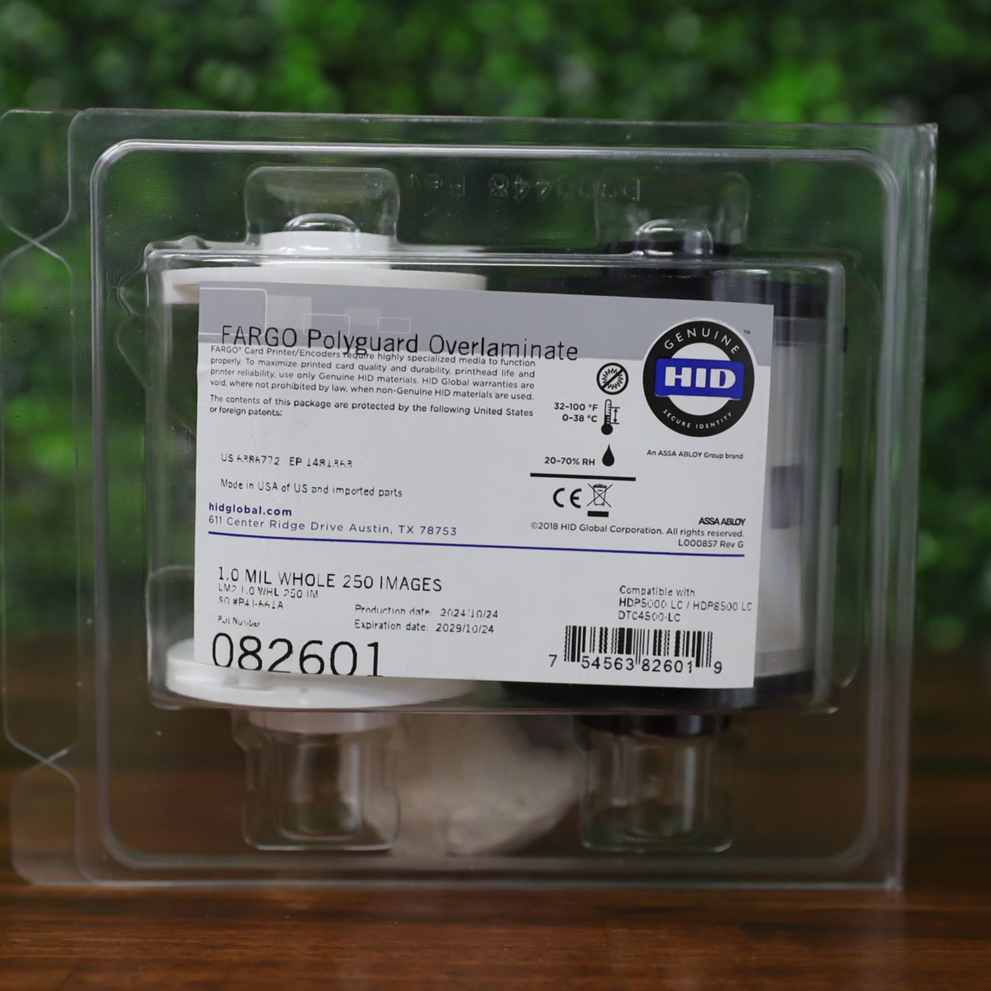 Front label view of the Fargo 82601 PolyGuard overlaminate ribbon, sealed in clamshell packaging with barcode, model number, and HID Genuine branding visible. Photographed and sold by Specialist ID, an authorized Fargo dealer.