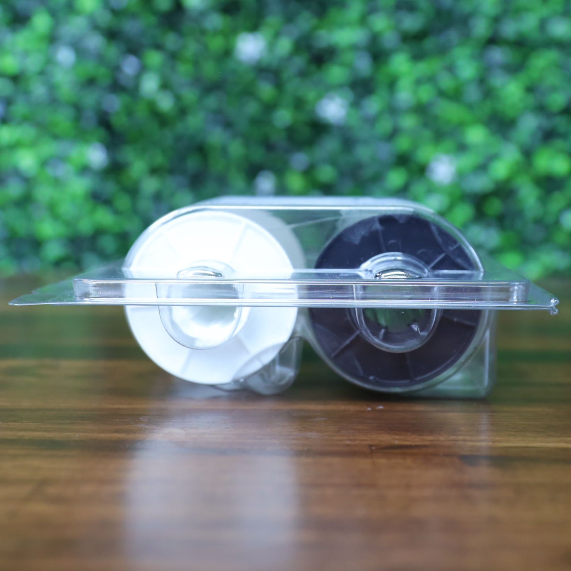 Alternate side angle of the Fargo 82601 PolyGuard laminate ribbon in its plastic packaging, highlighting the white and black spool ends with even lighting. Photographed and sold by Specialist ID, an authorized Fargo dealer.