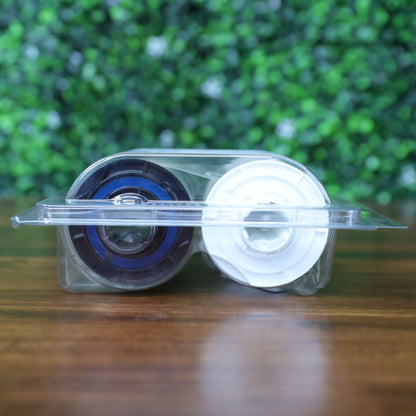 Side view of the Fargo 82601 PolyGuard laminate ribbon inside its clear clamshell packaging, showing the black and white reel hubs from a flat angle. Photographed and sold by Specialist ID, an authorized Fargo dealer.