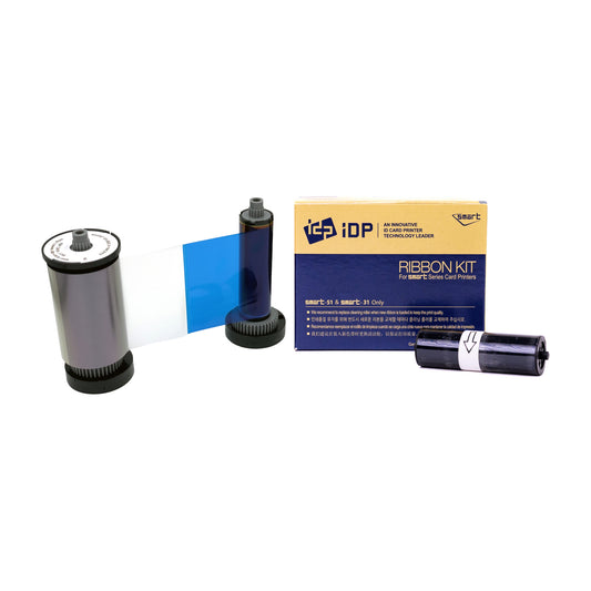 IDP 653307 YMCPKO pearlescent ribbon roll with silver-toned film and a cyan panel, its cleaning roller and IDP Ribbon Kit box marked SMART-51 and SMART-31 only