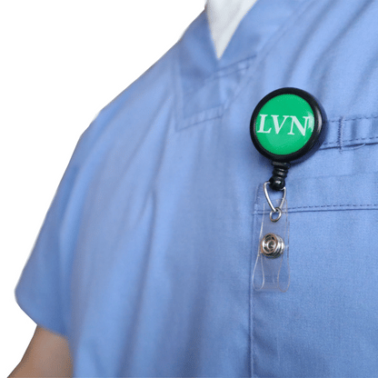 A person wearing blue scrubs with an LVN Badge Buddy Reel with Swivel Spring Clip, combining the LVN Badge Buddy and retractable reel in one for nurses, displaying "LVN" on a green background.