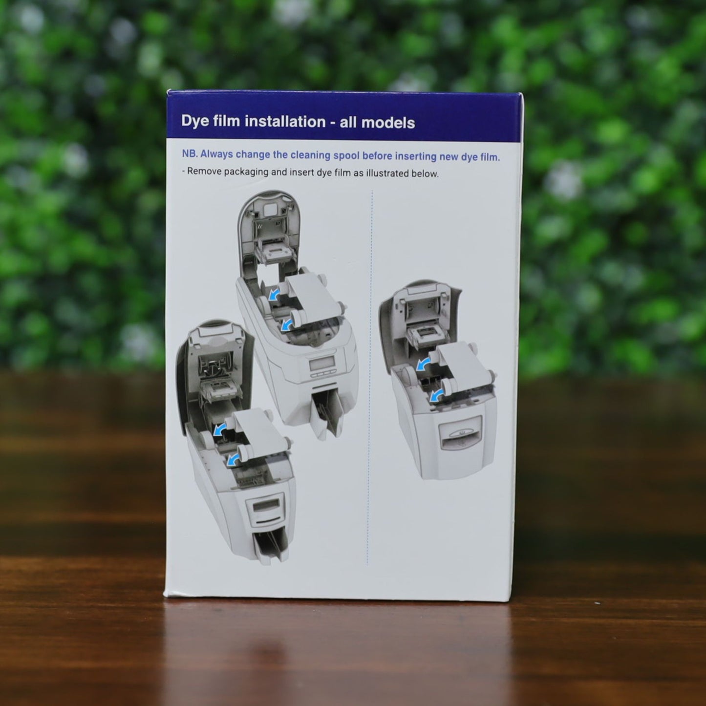 The Magicard MA300YMCKO YMCKO Color Ribbon - 300 Prints box shows three grayscale diagrams with clear instructions above, guiding users through dye film installation steps in the device. Photographed and sold by Specialist ID, an authorized Magicard dealer.