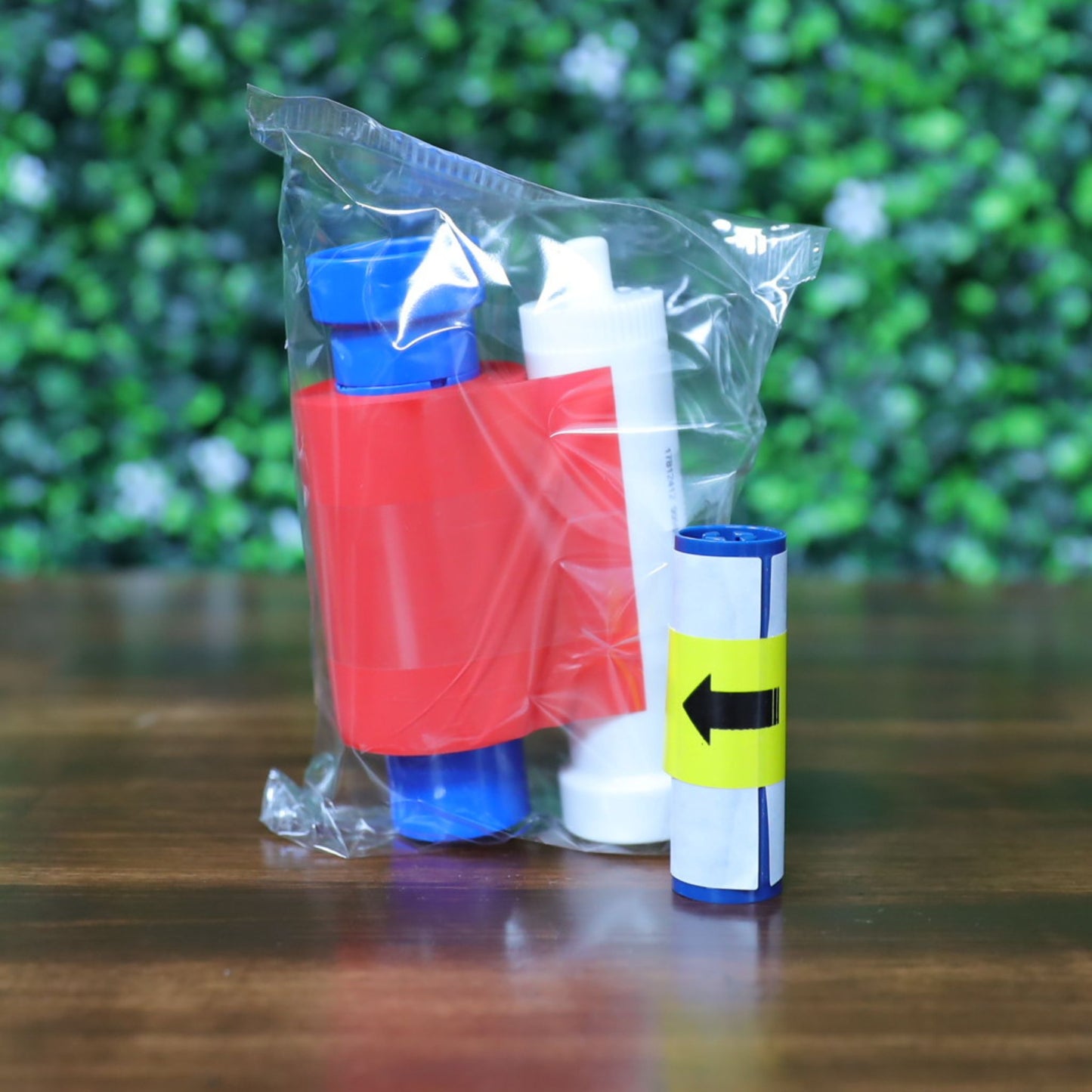 Magicard MA1000K-RED red monochrome ribbon shown with included white cleaning spool and adhesive roller, photographed in sealed plastic wrap. Photographed and sold by Specialist ID, an authorized Magicard dealer.