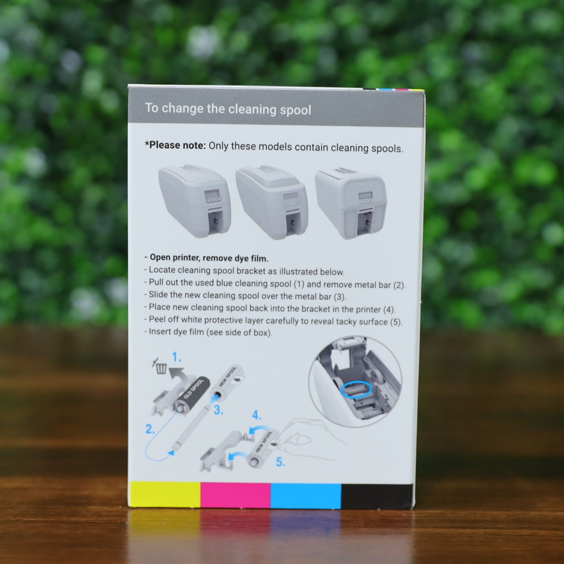 Back panel of the Magicard MC600KO/2 ribbon box showing cleaning spool replacement instructions. Includes illustrated step-by-step guide with labeled diagrams and a note specifying compatible printer models. Cyan, magenta, yellow, and black color bar is printed along the bottom.
Photographed and sold by Specialist ID, an authorized Magicard dealer.