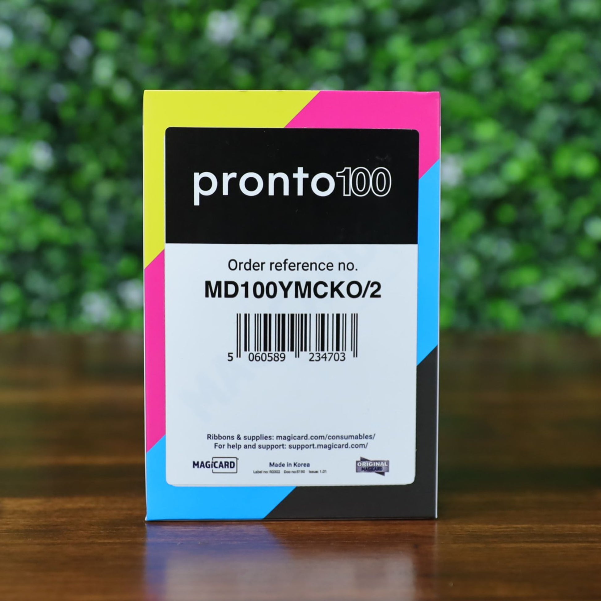 Front of the Magicard MD100YMCKO/2 ribbon box for the Pronto100 ID card printer. Displays part number, barcode, Magicard branding, and product origin (Made in Korea). Photographed and sold by Specialist ID, an authorized Magicard Dealer.