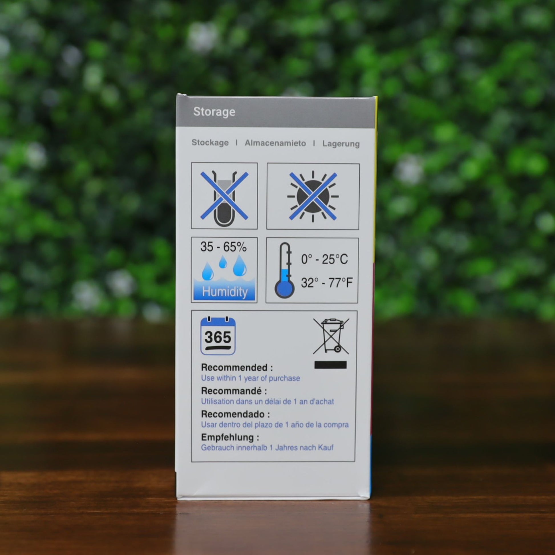Side of the Magicard MD100YMCKO ribbon box with storage instructions. Displays multilingual guidelines and icons for proper temperature (32–77°F), humidity (35–65%), UV protection, and shelf life (1 year). Photographed and sold by Specialist ID, an authorized Magicard Dealer.