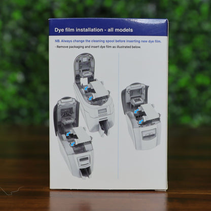 Back of the Magicard PR1000W monochrome ribbon box displaying dye film installation instructions for all compatible printer models. Includes step-by-step visual diagrams with arrows indicating proper placement. Blue header and instructional illustrations highlight printer lid and ribbon placement. Photographed and sold by Specialist ID, an authorized Magicard dealer.