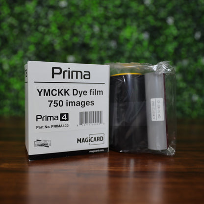 Magicard Prima433 YMCKK dye film ribbon (750 prints) displayed next to its labeled retail box on a wooden surface with a green foliage backdrop. Photographed and sold by Specialist ID, an authorized Magicard dealer.


