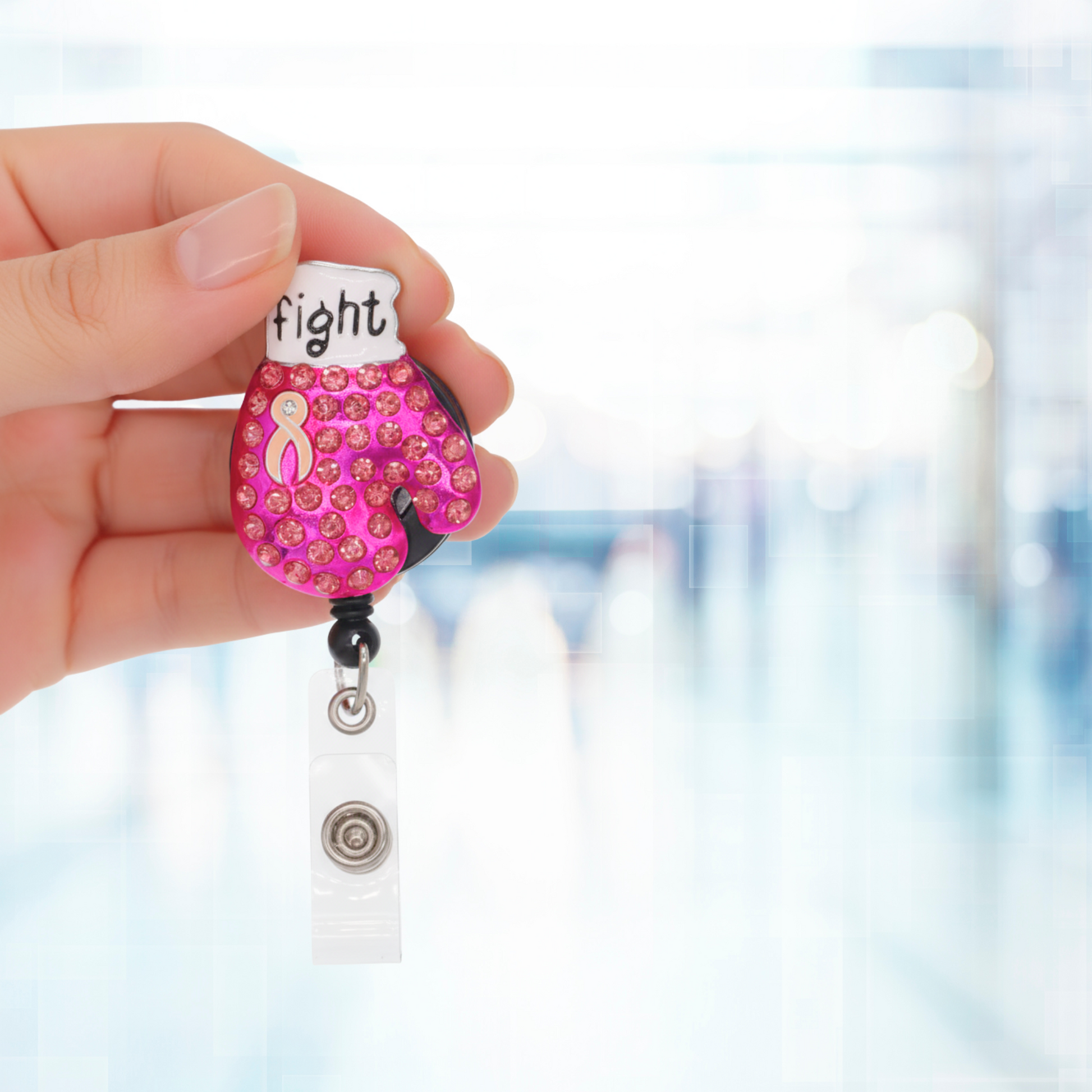 Hand holding a pink and white badge holder with 'fight' text against a blurred background. Sold by Specialist ID.
